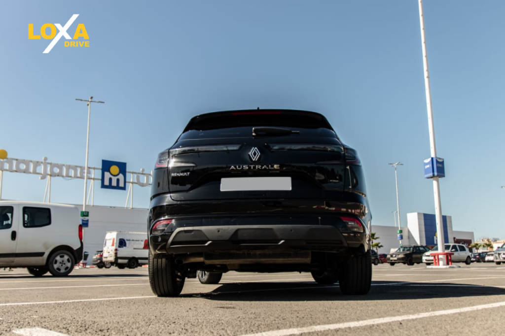 Luxury car rental in Marrakech with premium vehicle parked in front of traditional Moroccan architecture